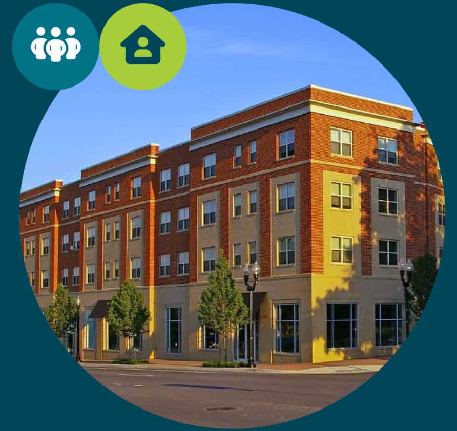 A modern, four-story apartment building with large windows and red brick accents, surrounded by small trees and a wide sidewalk, under a clear blue sky. Two icons are overlaid in the upper corners.