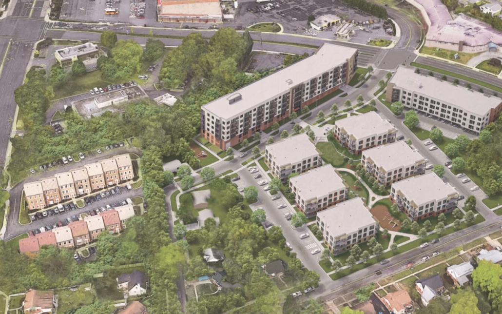 Aerial view of a residential complex with multiple apartment buildings, green spaces, trees, parking lots, and roads. Surrounding the complex are commercial buildings, more roads, and a wooded area.