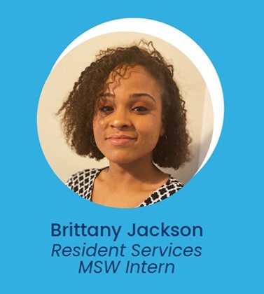 Portrait of a woman with curly hair, wearing a patterned top, with the text: Brittany Jackson, Resident Services MSW Intern on a blue background.