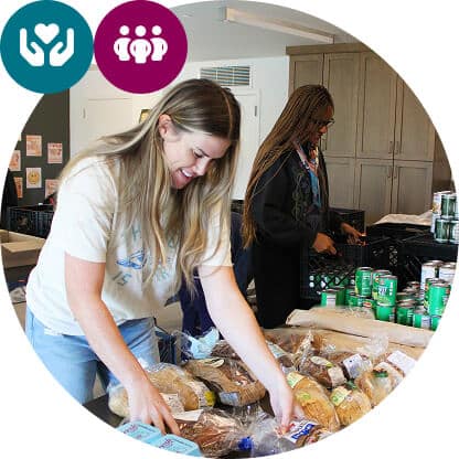 Two women sort and organize food items, including bread and canned goods, on a table in a pantry-like setting. Icons of hands holding a heart and three people appear in the top left corner.