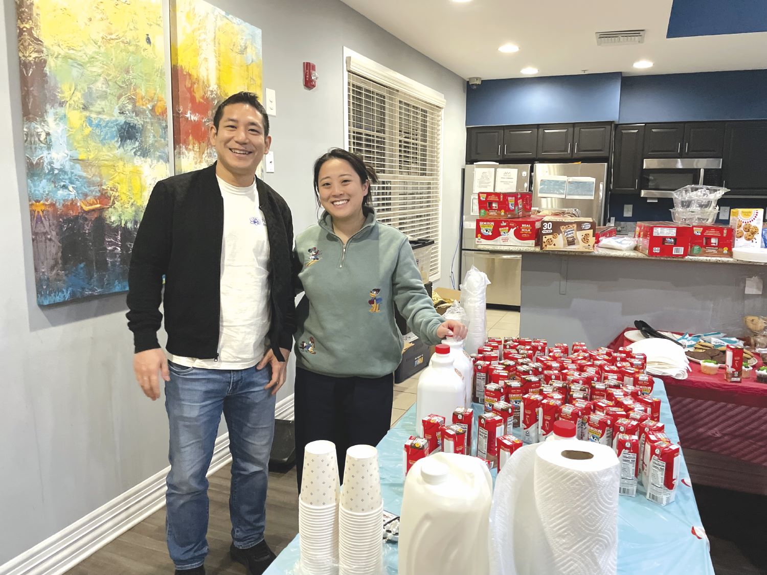 IMG_1086 A couple in a kitchen with a large amount of groceries on the counters